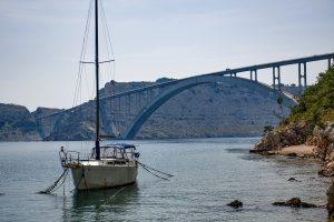 Segelboot in der Nähe der riesigen Bogenbrücke